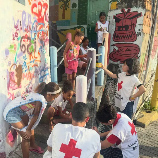 Crianças e voluntários revitalizam uma escadaria comunitária.