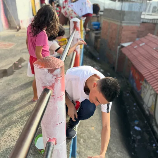 Voluntária e criança sorriem juntas durante a ação.